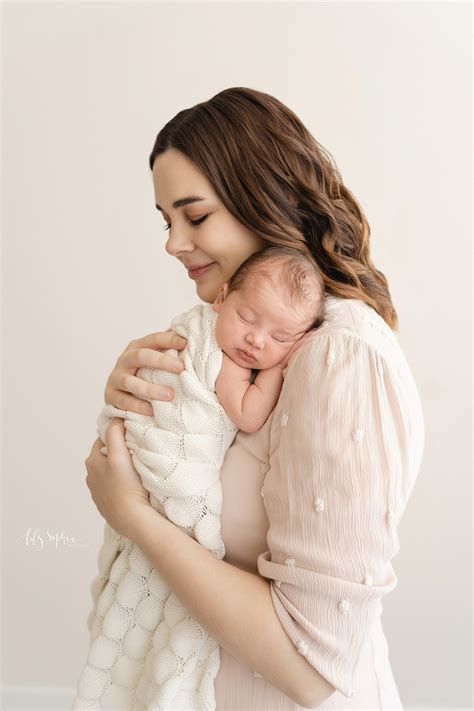 New Mother Smiles As She Holds Her Sleeping Infant Daughter To Her