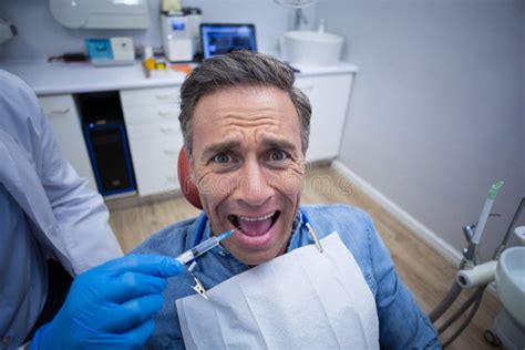 Dentista Que Inyecta Los Anestésicos En Boca Paciente Masculina