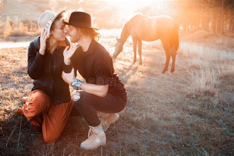 Happy And Loving Couple In The Setting Sun On A Horse Farm Image