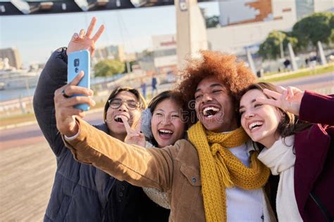 Cheerful Mixed Race Of Group Of Friends Taking Selfie Outdoors Wearing Winter Clothes Stock