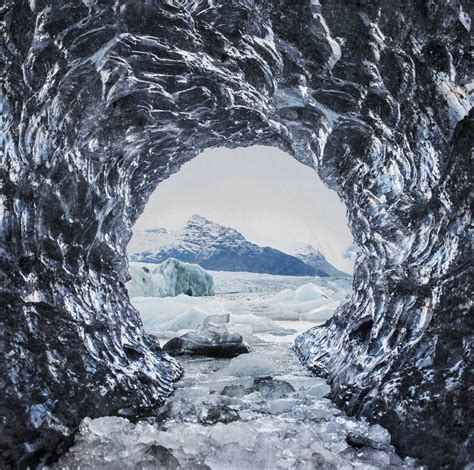 Mountains Seen Through Ice Cave Stock Photo