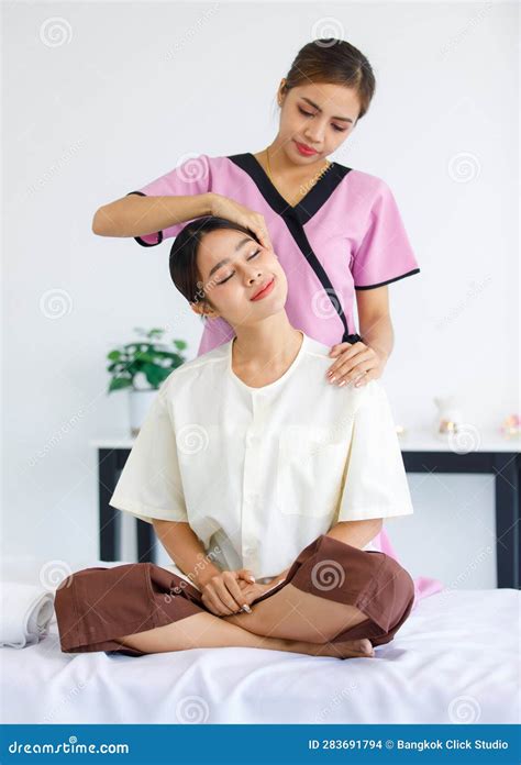 Millennial Asian Professional Female Thai Masseuse Aromatherapy Therapist In Uniform Sitting On