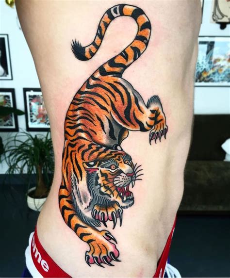 a tiger tattoo on the side of a woman s lower body showing it s claws