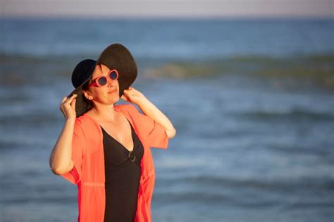 premium photo happy mature woman enjoying on sea beachelderly woman in a hat on a background