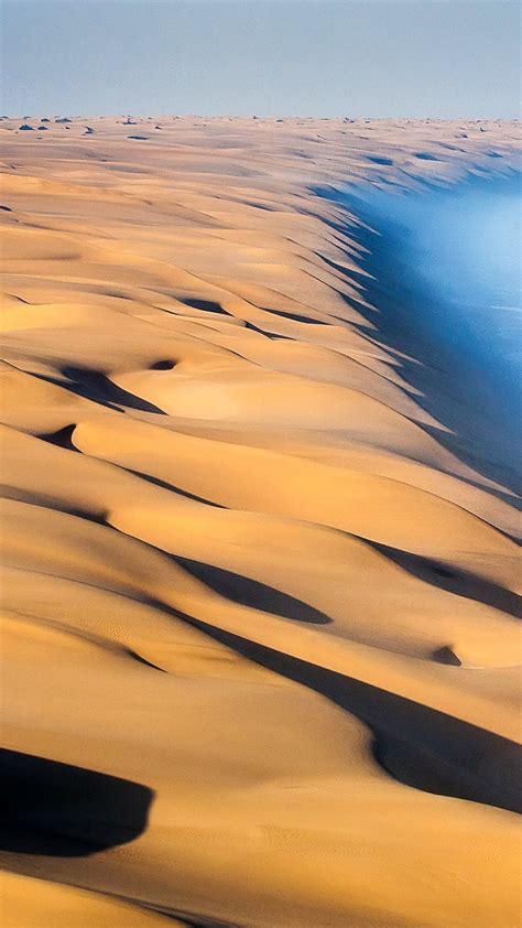 Deserts are defined by having very little precipitation. Dunes of the Namib Desert meet the Atlantic Ocean, Namibia ...
