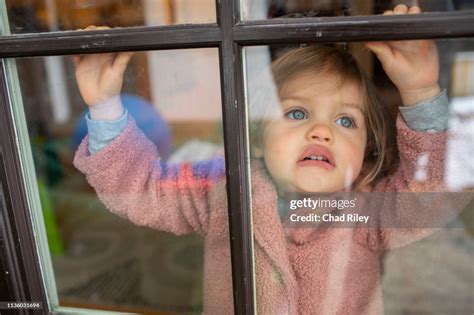 Young Girl Pressing Her Face Against Window And Acting Silly High Res