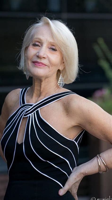 An Older Woman In A Black And White Dress With Her Hands On Her Hips Posing For The Camera