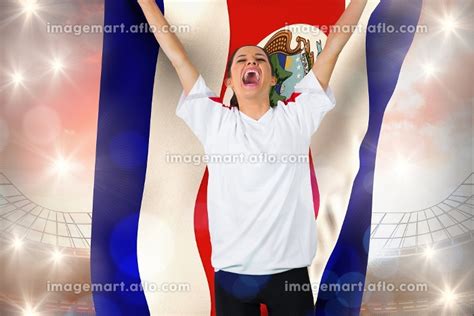 Football Fan In White Cheering Holding Costa Rica Flag Against Large Football Stadium Under