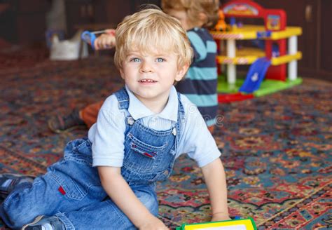 Little Baby Boy With Blue Eyes And Blond Hairs Indoor With