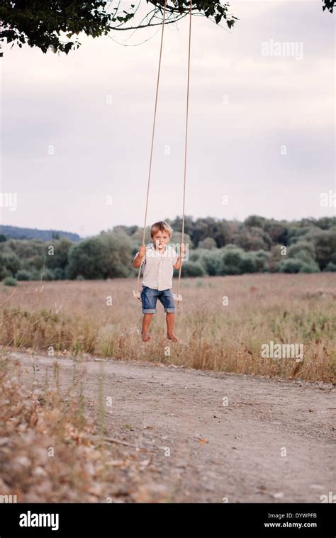 Happy Young Boy Playing On Swing In A Park Stock Photo Alamy