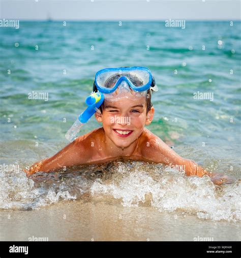 Happy Boy Wearing Snorkeling Gear Lying In The Sea Stock Photo Alamy