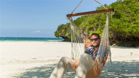 Man Relaxing In A Hammock On The Beach On Holidays Stock Photo Image