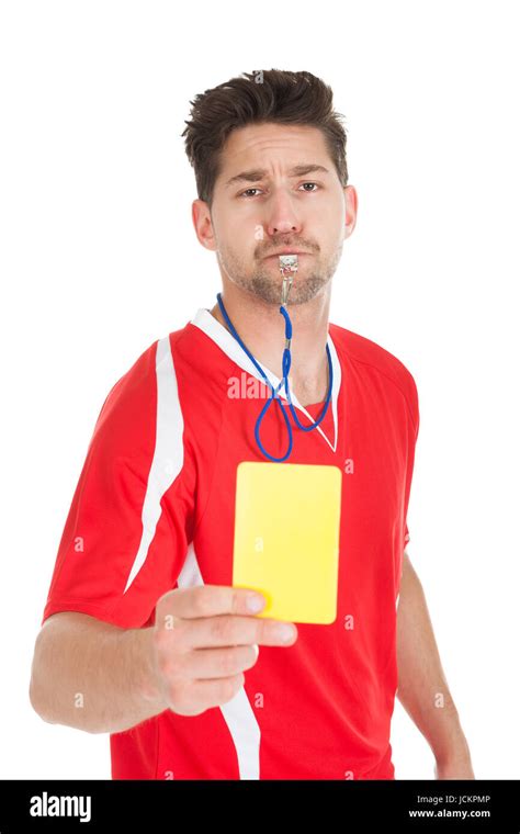 Portrait Of Referee Blowing Whistle While Showing Yellow Card Over