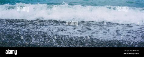 Stormy Sea Waves With Spindrift Washing Empty Pebble Beach Stock Photo