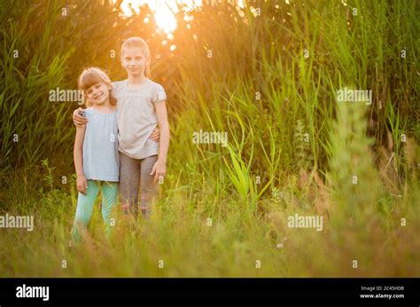 Little Kid Best Friends Hugging Outdoor At Summer Sunset Stock Photo