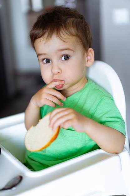 El Niño Hambriento Un Niño Pequeño Sentado En Una Silla Alta Comiendo
