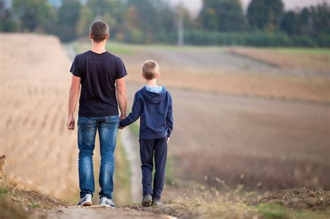 Premium Photo Back View Of Young Father And Son Walking Together