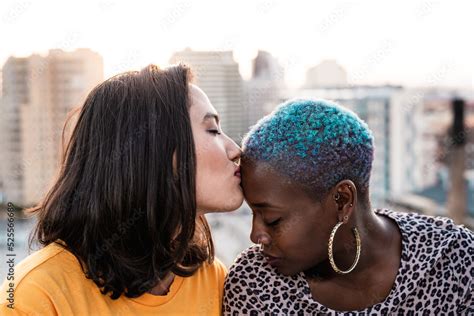 Multiracial Lesbian Couple Sitting Close Together Outdoors Stock Photo Adobe Stock