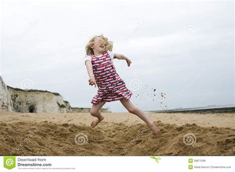 Jong Meisje Die Op Een Strand Springen Stock Afbeelding Afbeelding