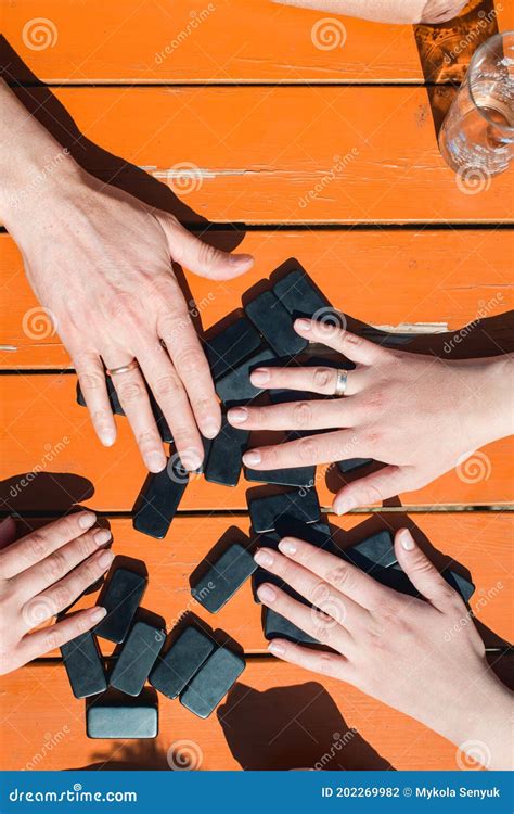 People Playing Domino Game For Leisure Orange Table Stock Photo