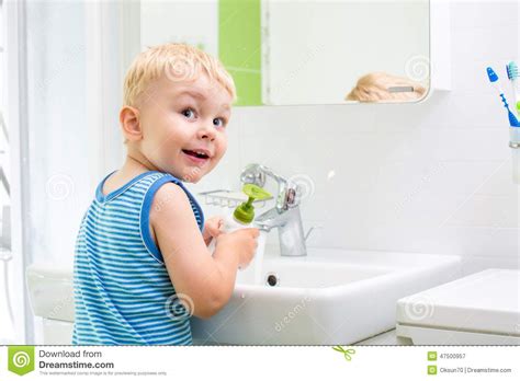 Keeping your baby's skin clean is essential to good health, and bath time is also a wonderful bonding experience. Kid Washing His Face And Hands In Bathroom Stock Photo ...