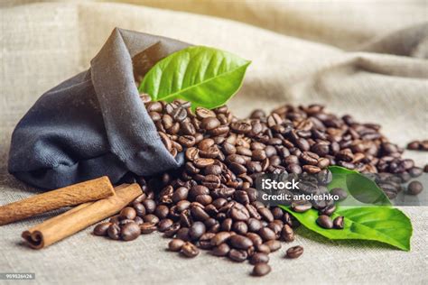 커피 원두와 녹색의 더미 흰색 린 넨 바탕에 가방에 나뭇잎 신선한 음료의 생산의 개념입니다 0명에 대한 스톡 사진 및 기타
