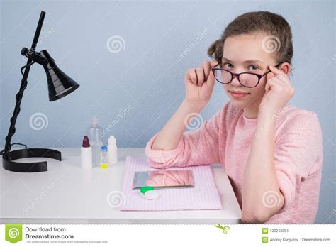 The Girl Takes Off Her Glasses Sitting At The Table In Order To Wear
