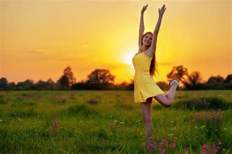 Happy Cheerful Girl Is Jumping On Nature Over The Summer Sunset Stock