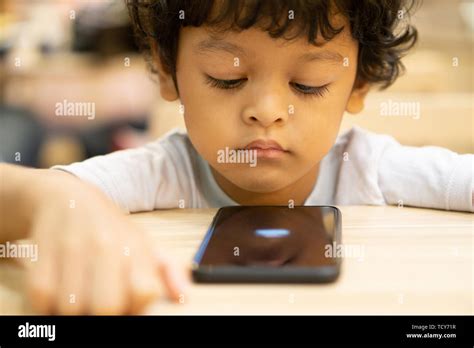 Cute Asian Little Boy Is Playing A Game On Smartphone Stock Photo Alamy