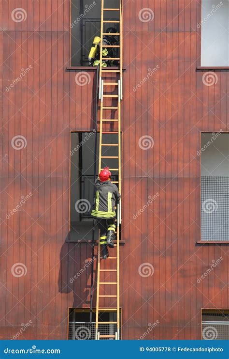 Firefighters On The Wooden Ladder During Firefighting Stock Photo