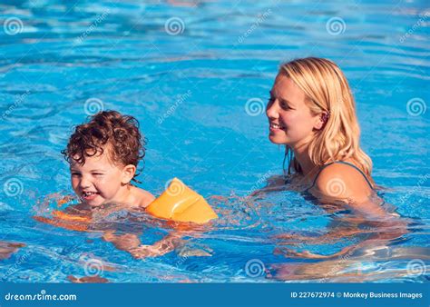 母亲和儿子在室外游泳池中度暑假，教儿子用充气臂带游泳 库存照片 图片 包括有 äº å — å¸®åš© 227672974