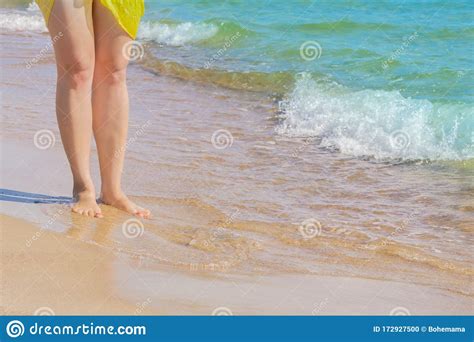 Hermosas Piernas De Mujer En Una Playa De Arena En Agua De Mar Foto De