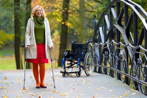 Woman Practicing Walking On Crutches Stock Image Image Of Trees Coat