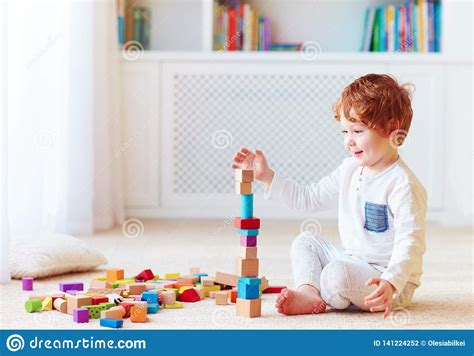 Cute Toddler Baby Boy Playing With Wooden Blocks Building A Balancing