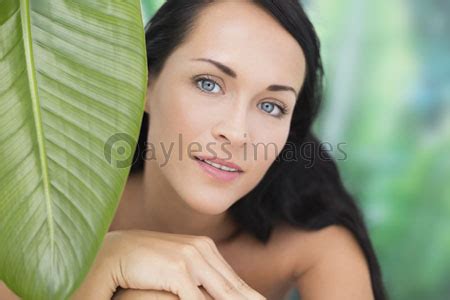 Beautiful Nude Brunette Smiling At Camera With Green Leaf