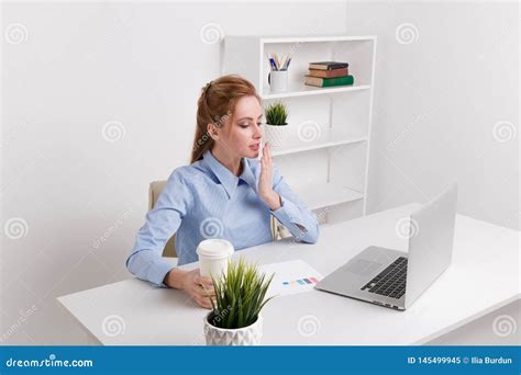 giovane segretaria che si siede alla sua sensibilit del posto di lavoro sonnolenta immagine