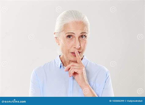 Beautiful Old Woman Showing Silence Gesture Looking At Camera Stock