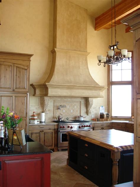 Gorgeous kitchen features a high ceiling with a dark stained truss ceiling over white cabinets paired with white marble countertops and backsplash. Kitchen High Ceiling Range Hood Detail