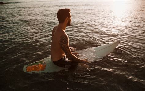 Free Photo Man Sitting On Surfboard In Sea Water