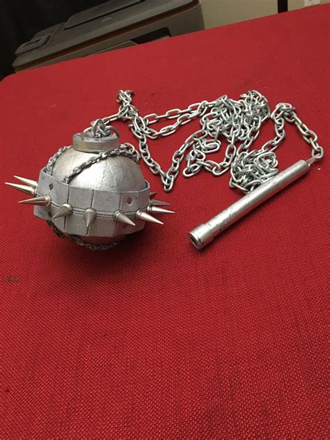 A Metal Ball And Chain On A Red Surface