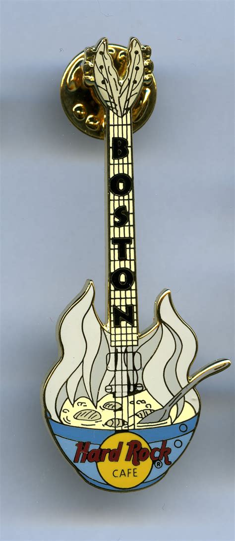 A Yellow And Black Guitar Shaped Pin Sitting On Top Of A White Table