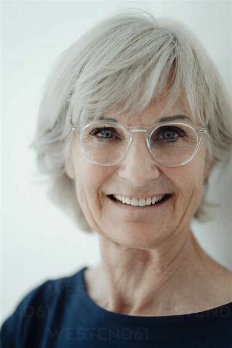 Smiling Senior Woman Wearing Eyeglasses Against White Background Stock