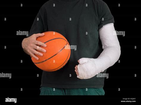 Young Man Sporting A Bright White Arm Cast Holding A Basketball After