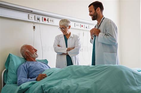 Doctor Consulting Happy Senior Man Patient On Hospital Bed Healthcare