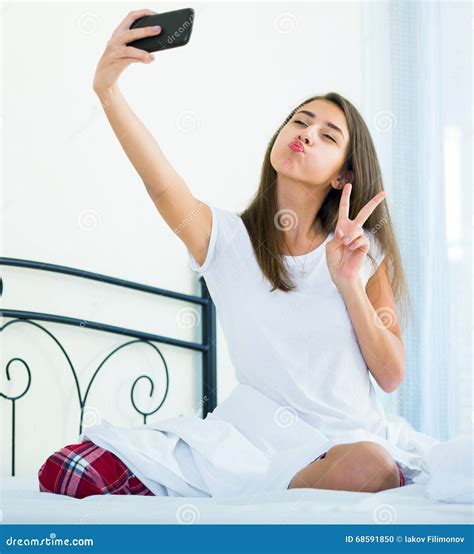 Gelukkige Vrouwelijke Tiener Die Selfie In Bed Doen Stock Foto Image