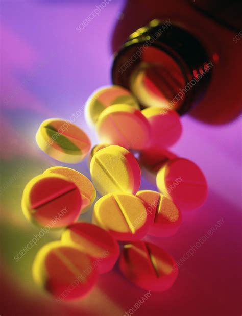 Painkilling (analgesic) pills spilling from bottle - Stock Image - M630
