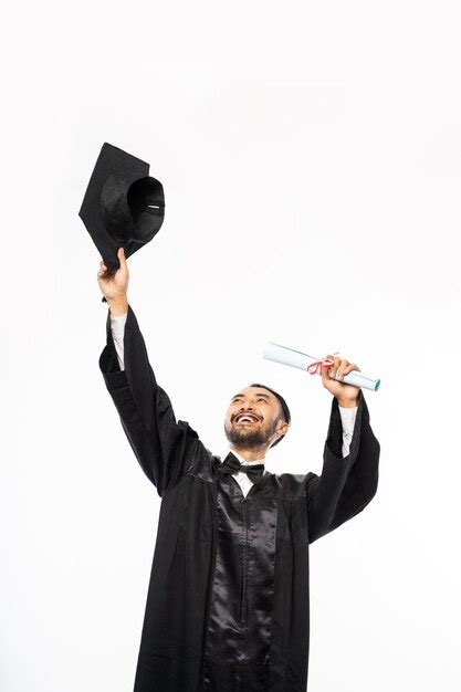 Premium Photo Happy Graduate In Black Togas Holding Up Toga Hat On