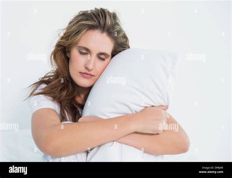 Woman Hugging Pillow Sitting On Her Bed Stock Photo Alamy