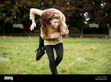 Young Man Carrying Woman On Shoulder At Park Stock Photo Alamy