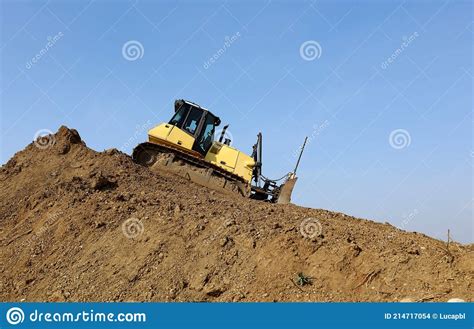 Bulldozer At Work On The Descent Of A Large Pile Of Dirt Stock Photo